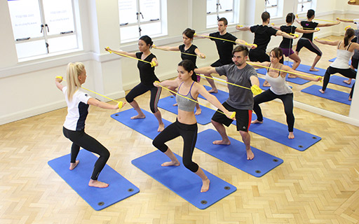 Pilates instructing a group pilates class