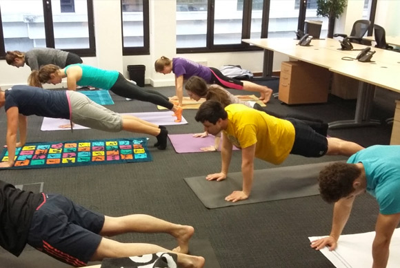 people doing pilates in an office environment.